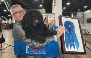 Glen and Blu seem equally proud to display one of their blue ribbons. RVing makes the dog show circuit easier for both humans and canines.